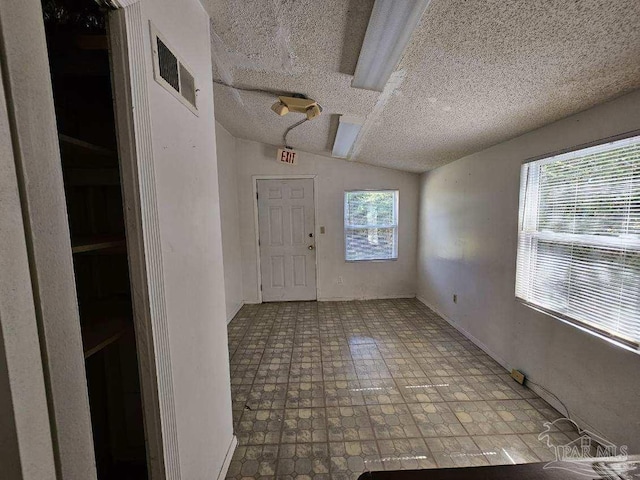 entrance foyer with lofted ceiling and a textured ceiling