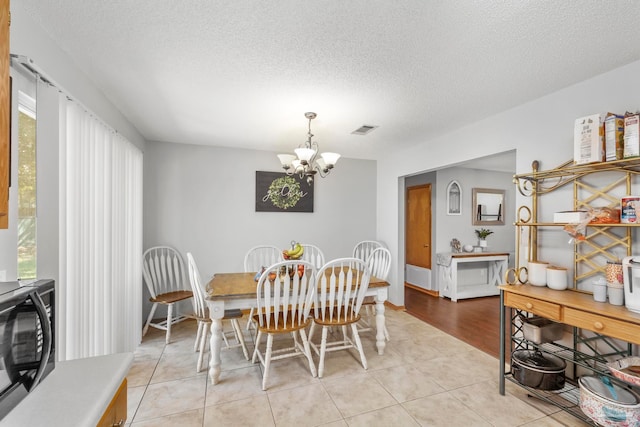 dining room featuring an inviting chandelier, a healthy amount of sunlight, and light tile patterned flooring