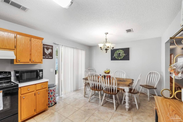 kitchen with light tile patterned flooring, black appliances, range hood, a notable chandelier, and decorative light fixtures