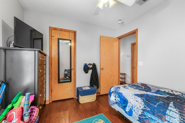 bedroom featuring a textured ceiling, dark hardwood / wood-style floors, and ceiling fan