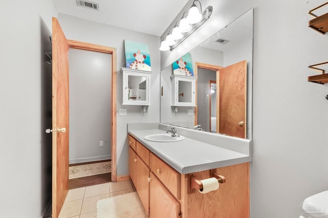 bathroom featuring vanity, a textured ceiling, and tile patterned flooring