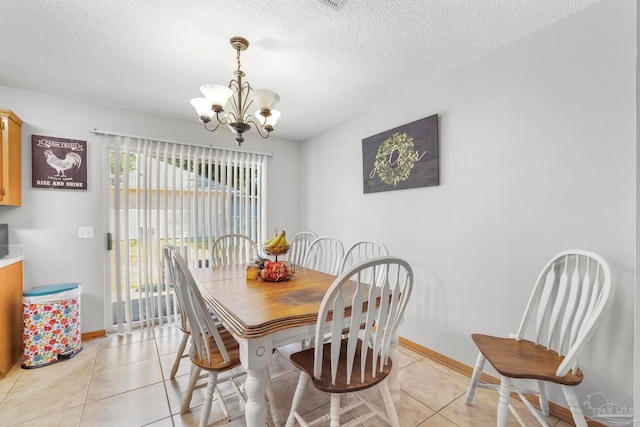 dining space with light tile patterned flooring, a textured ceiling, and an inviting chandelier