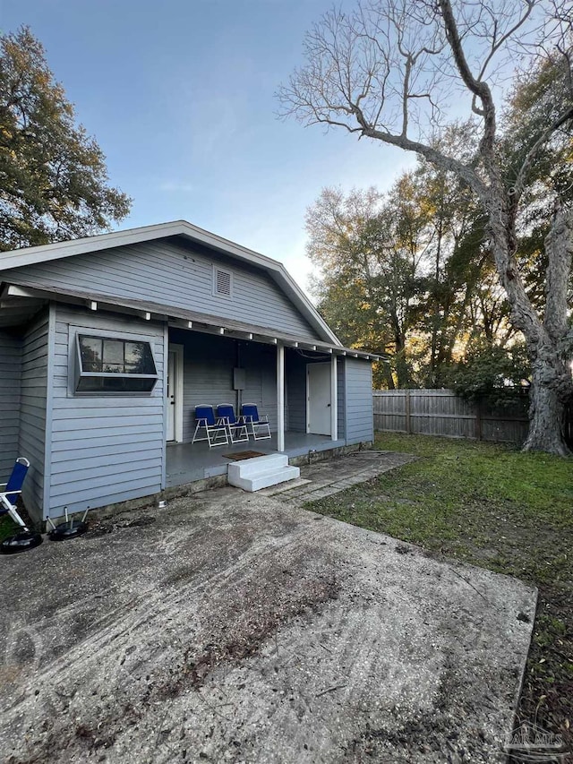 back of property featuring covered porch and fence