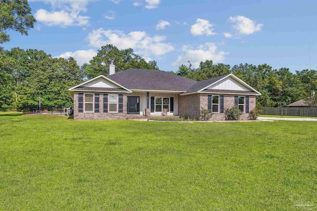 ranch-style house with brick siding, a chimney, fence, and a front yard