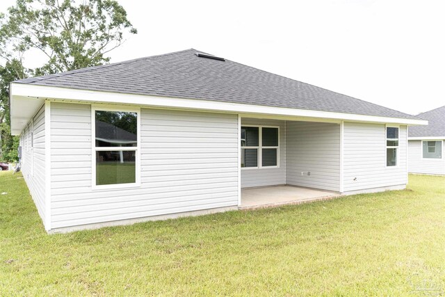 back of property with a patio area and a lawn