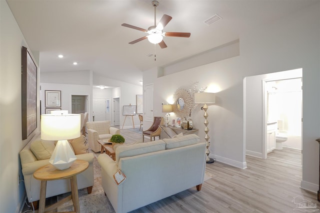 living room featuring ceiling fan, light hardwood / wood-style floors, and vaulted ceiling