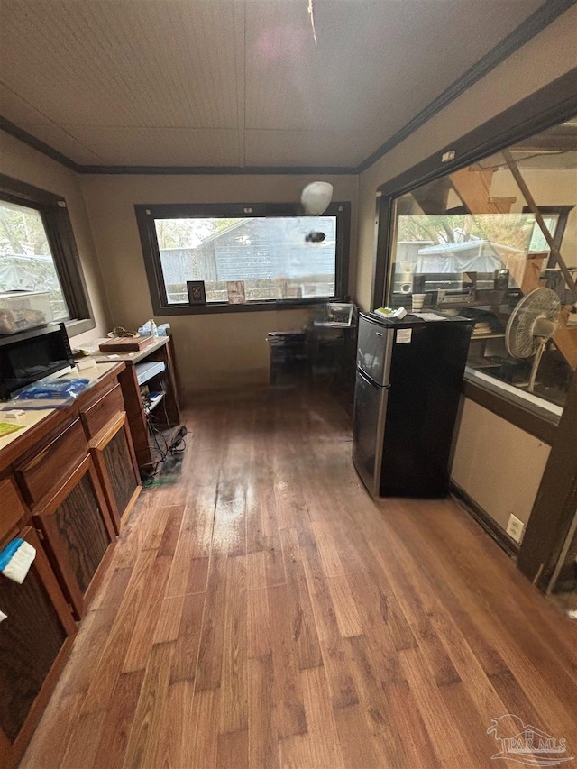 interior space with hardwood / wood-style flooring, plenty of natural light, and ornamental molding