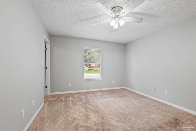 carpeted spare room with ceiling fan and a textured ceiling