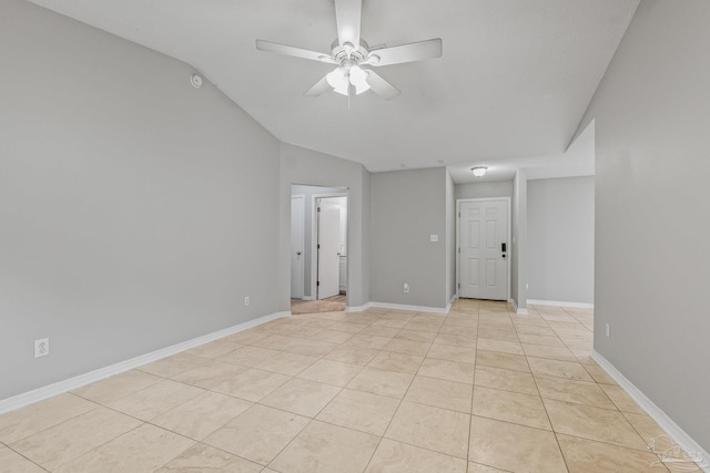 tiled empty room featuring vaulted ceiling and ceiling fan