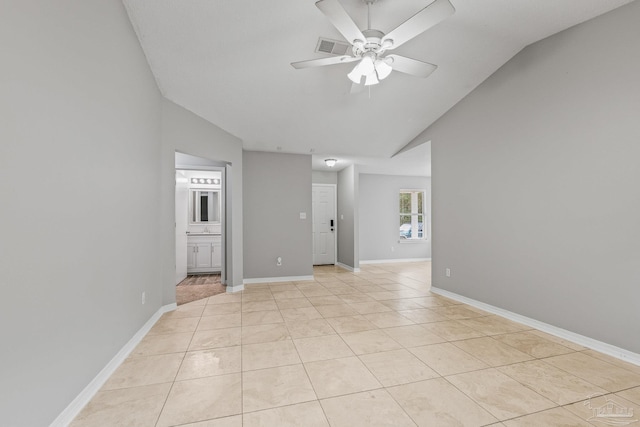 tiled empty room featuring vaulted ceiling and ceiling fan