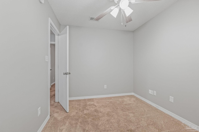 carpeted empty room featuring ceiling fan and a textured ceiling