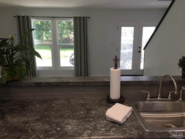 3385 Olive Rd Unit 2-D, Pensacola, FL 32514 - kitchen view of a sink, french doors, dark stone counters, and decorative backsplash