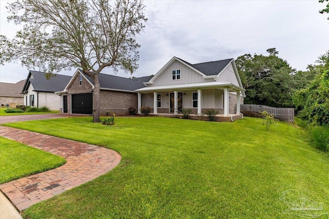 view of front of home featuring a garage, a front lawn, and covered porch