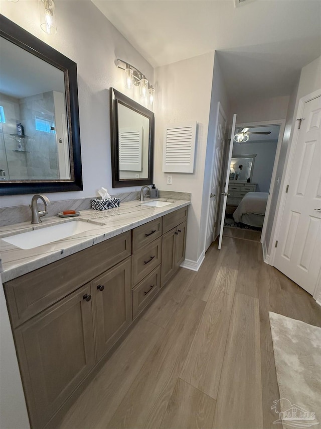 1450 N 11th Ave, Pensacola, FL 32503 - bathroom featuring connected bathroom, double vanity, wood finished floors, and a tile shower