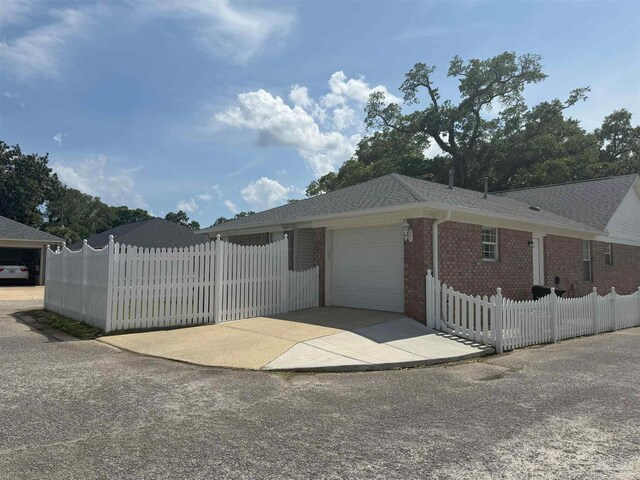 1450 N 11th Ave, Pensacola, FL 32503 - view of front facade with a garage, concrete driveway, brick siding, and roof with shingles