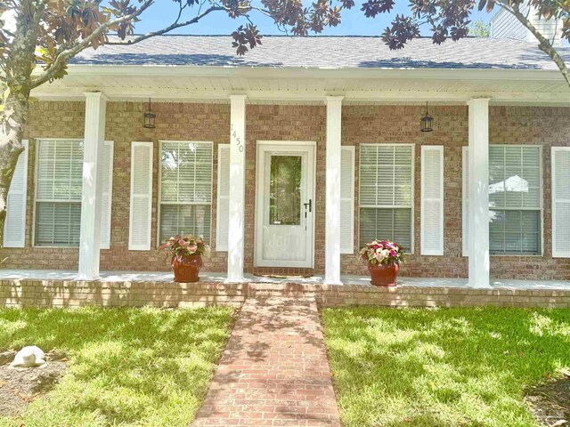 1450 N 11th Ave, Pensacola, FL 32503 - entrance to property featuring a porch, brick siding, and a shingled roof