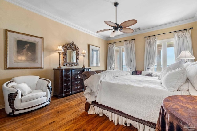 bedroom with hardwood / wood-style flooring, ceiling fan, and ornamental molding