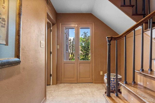 doorway featuring light tile patterned floors and lofted ceiling