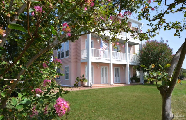 view of front of home with a balcony and a front yard