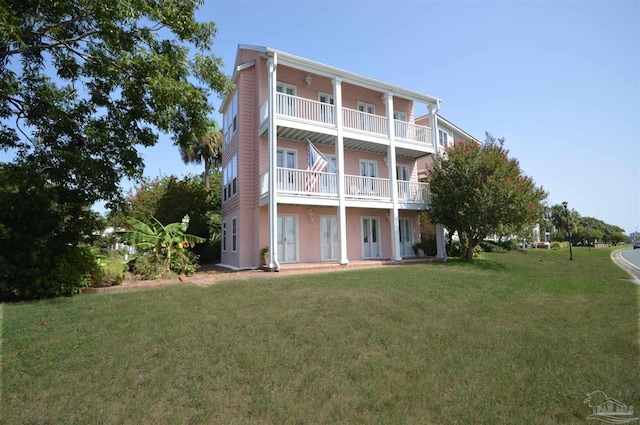 back of property featuring a yard and a balcony