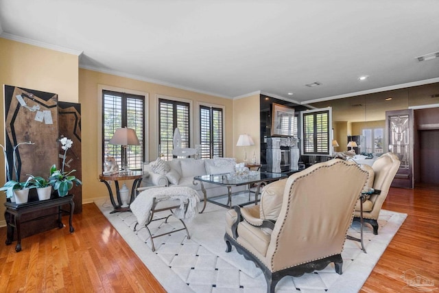 living room featuring light wood-type flooring and ornamental molding