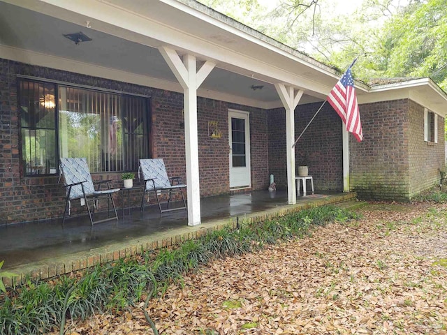 rear view of house with a porch and brick siding
