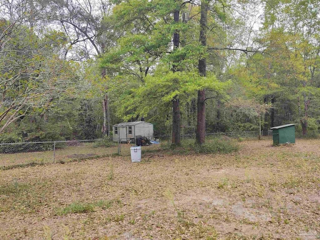 view of yard featuring an outbuilding, a fenced backyard, and a storage unit