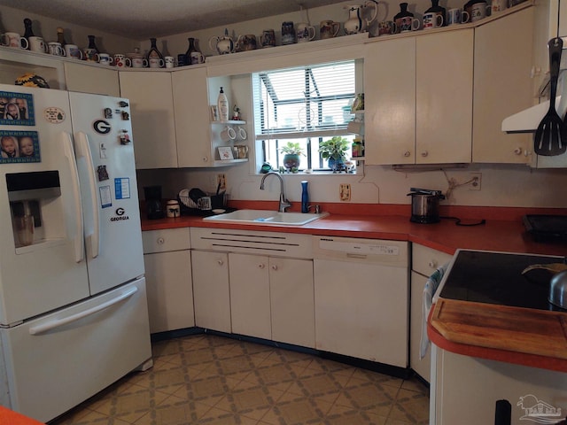 kitchen with a sink, white appliances, white cabinets, and light floors