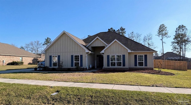 view of front of home with board and batten siding, a front lawn, and fence