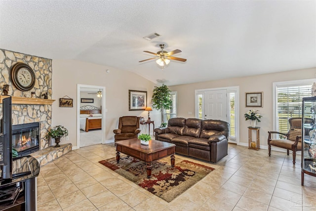 living area featuring light tile patterned floors, visible vents, lofted ceiling, and a ceiling fan