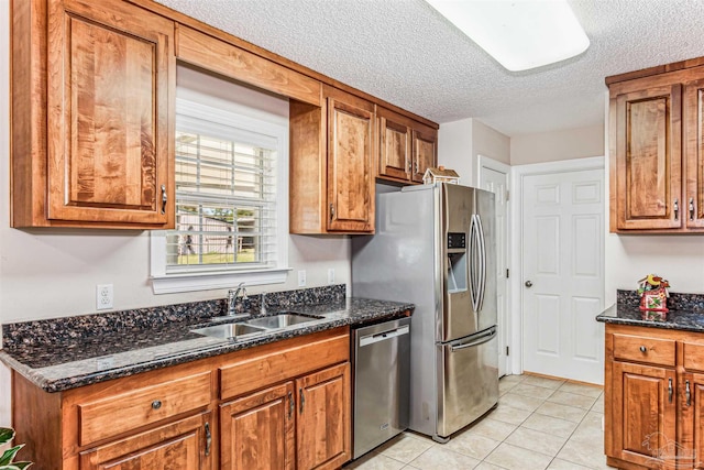 kitchen with brown cabinetry, appliances with stainless steel finishes, and a sink
