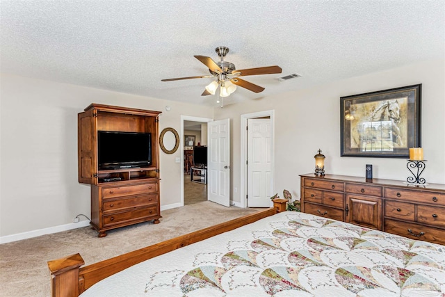bedroom with light carpet, visible vents, a textured ceiling, and baseboards