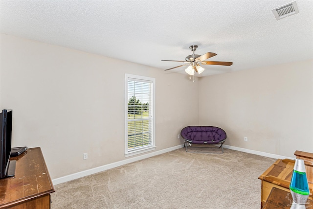 sitting room with visible vents, carpet flooring, baseboards, and a ceiling fan