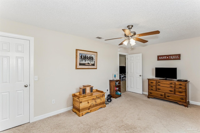 bedroom with visible vents, baseboards, ceiling fan, carpet flooring, and a textured ceiling