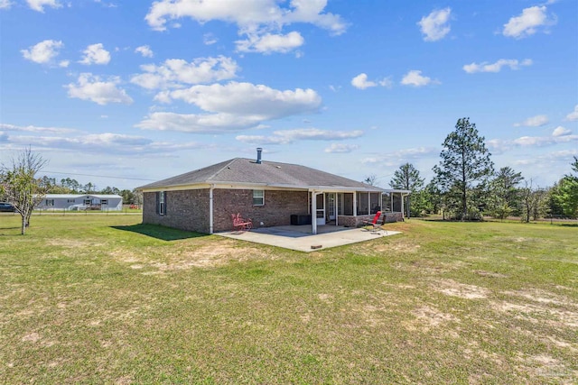 back of house with a yard, a patio area, brick siding, and a sunroom