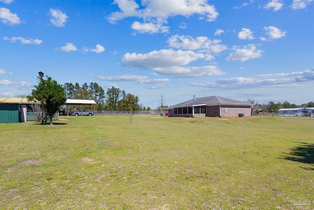 view of yard with a detached carport and a sunroom