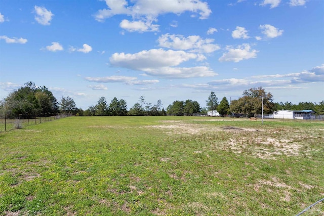 view of yard featuring a rural view and fence