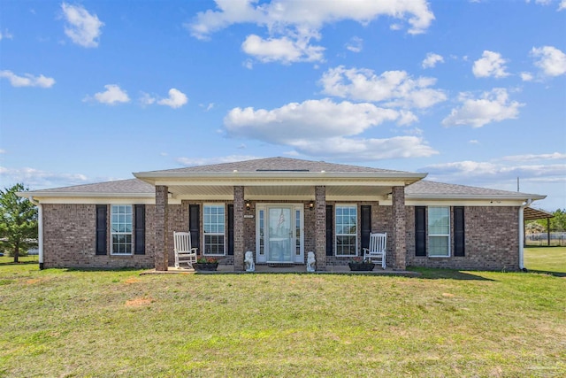 rear view of property featuring a lawn, covered porch, and brick siding