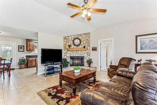 living area with lofted ceiling, a textured ceiling, light tile patterned flooring, and a ceiling fan