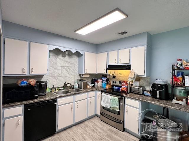 kitchen with white cabinets, stainless steel range with electric cooktop, a sink, light wood-style floors, and black dishwasher