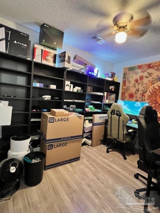 storage room with visible vents and ceiling fan