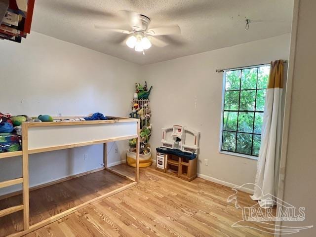bedroom with baseboards, a ceiling fan, and wood finished floors