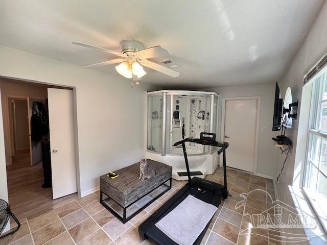 workout room with visible vents, baseboards, and ceiling fan