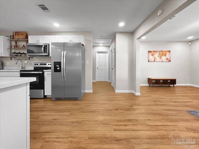 202 Henry St, Pensacola, FL 32507 - kitchen featuring stainless steel appliances, white cabinetry, baseboards, light countertops, and light wood-style flooring