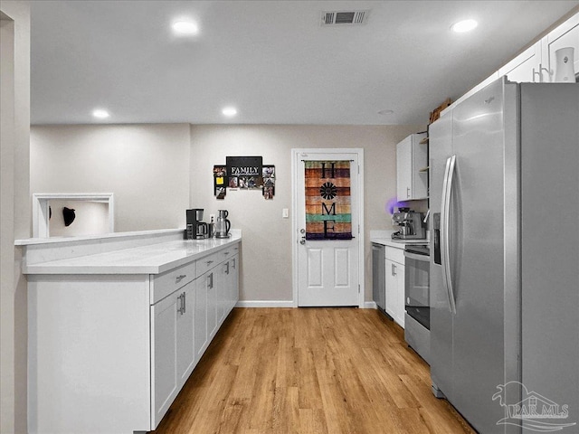 202 Henry St, Pensacola, FL 32507 - kitchen featuring appliances with stainless steel finishes, white cabinetry, light wood-type flooring, recessed lighting, and light countertops