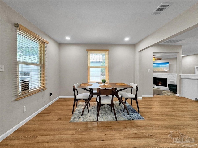 202 Henry St, Pensacola, FL 32507 - dining room featuring light wood finished floors, a lit fireplace, baseboards, recessed lighting, and ceiling fan