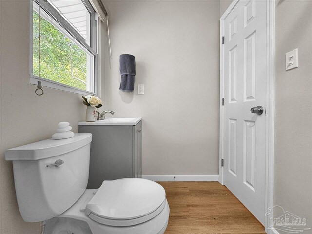 202 Henry St, Pensacola, FL 32507 - half bath with vanity, toilet, wood finished floors, and baseboards