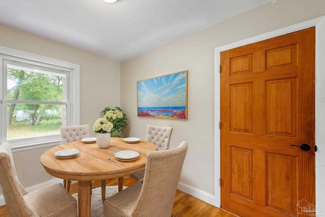 dining room featuring baseboards and light wood-type flooring