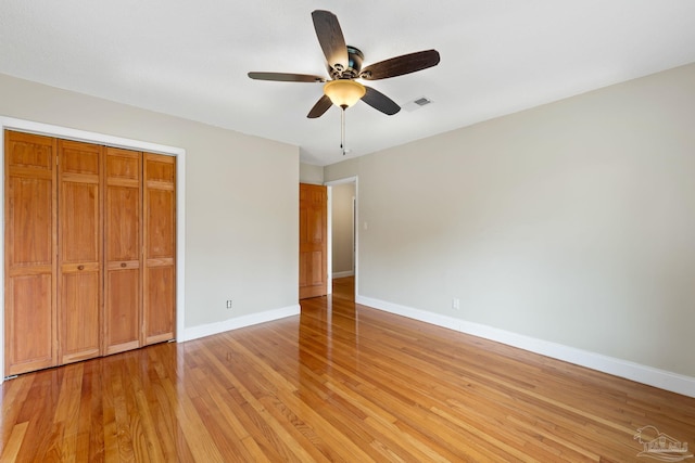 unfurnished bedroom with a ceiling fan, baseboards, light wood-style floors, and visible vents