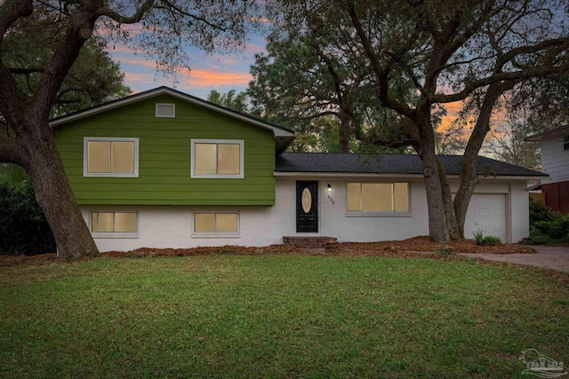 split level home with a lawn and an attached garage